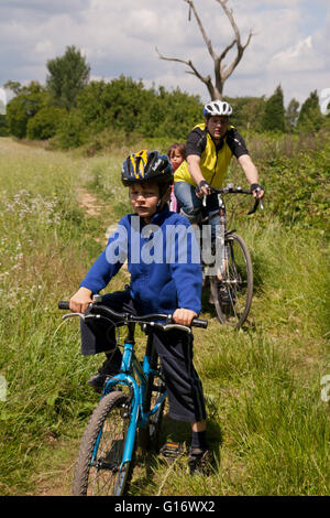 family out cycling in thhe British countryside in Kent UK Stock Photo