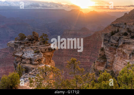 The sun breaks through the clouds in the East over the canyon seen from Mather Point in Grand Canyon National Park, Arizona. Stock Photo