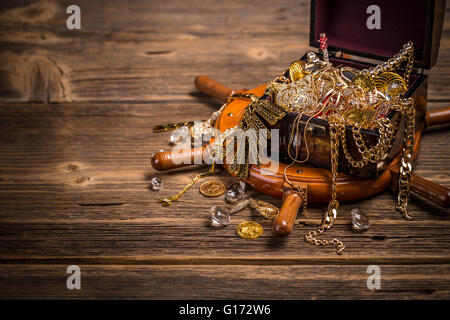 Pirates chest with golden jewelry on wooden background Stock Photo