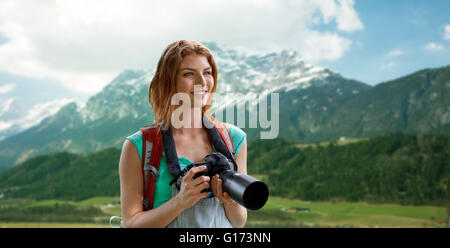 woman with backpack and camera over mountains Stock Photo