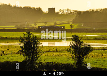 Train passing in front of Arnside Tower in the Arnside-Silverdale Area of Outstanding Natural Beauty Cumbria England Stock Photo