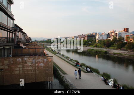 People relax at the Kamo river riverbank in the central of Kyoto, Japan. Stock Photo