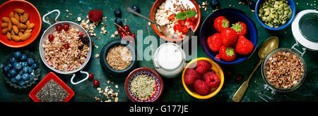 Healthy breakfast of muesli, berries with yogurt and seeds on dark background -  Healthy food, Diet, Detox, Clean Eating or Vege Stock Photo