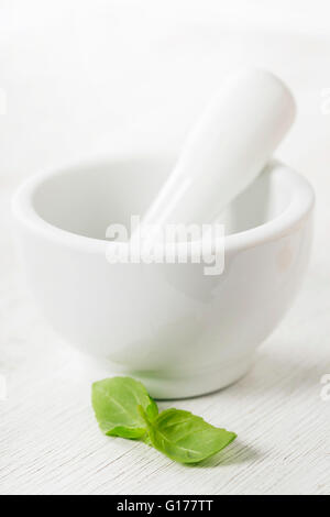 Ceramic Mortar with Pestle and basil over white Stock Photo