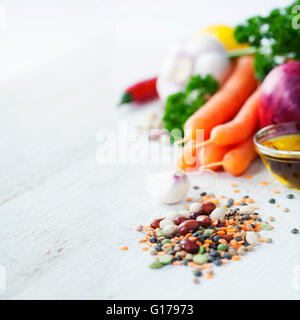 Mix of red  bean, lentil, green peas and chickpeas with vegetables over white Stock Photo