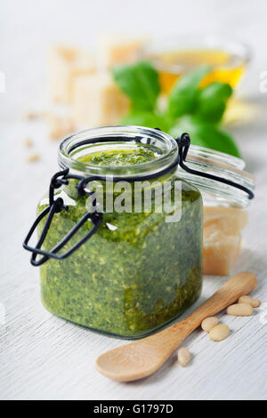 Homemade traditional basil pesto and ingredients on a rustic wooden table Stock Photo
