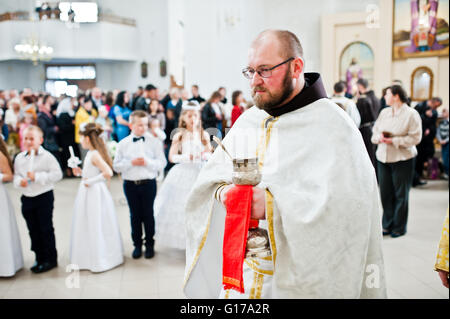 LVIV, UKRAINE - MAY 8, 2016: Priest at ceremony of a First Communion in the Church of St. Peter the Great of Ukrainian Greek Cat Stock Photo