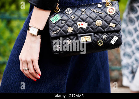 Black Chanel bag with badges and medals - Street Style, Paris Fashion Week RTW 2016-2017 Stock Photo