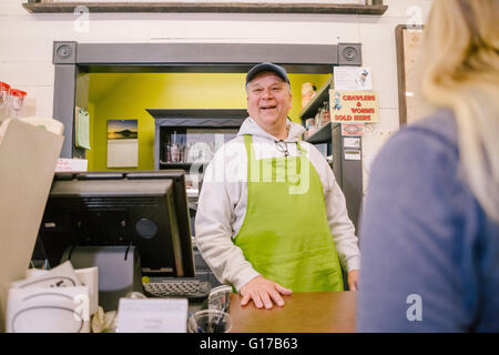 Owner in general store serving customer at counter Stock Photo