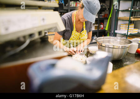 Employee in general store writing notes in kitchen Stock Photo