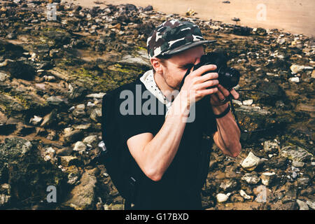 Male photographer photographing on beach, Crystal Cove State Park, Laguna Beach, California, USA Stock Photo