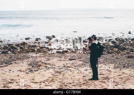 Male photographer photographing from beach, Crystal Cove State Park, Laguna Beach, California, USA Stock Photo