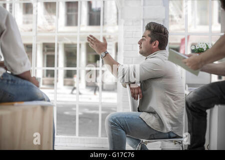 Businessman and colleagues brainstorming in loft office Stock Photo