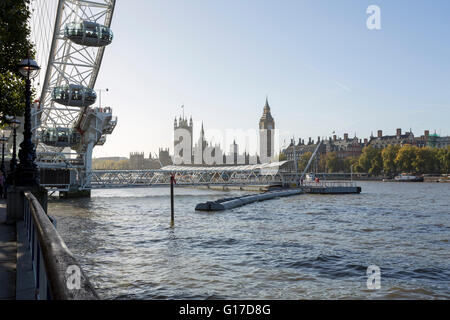 Festival Pier with London Eye and the Houses of Parliament on the Thames riverbanks in London at daylight Stock Photo