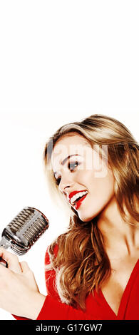Beautiful blonde woman in red dress smiling and holding a microphone, low angle close up portrait on white Stock Photo