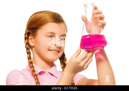 Young chemist pouring pink reagent in glass retort Stock Photo