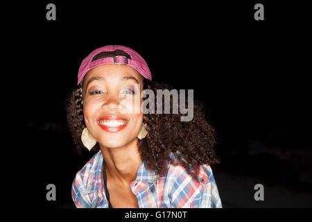 Portrait of young woman wearing baseball cap backwards looking at camera smiling Stock Photo