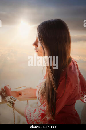Woman on balcony, looking at desert view Stock Photo