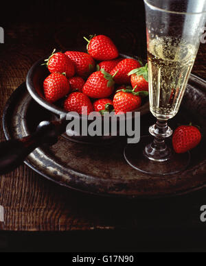 Vintage bowl with strawberries, and glass of champagne, on pewter plate, close-up Stock Photo