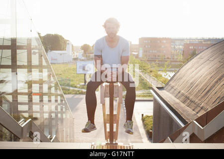 Portrait of man sitting on hand rail after training Stock Photo