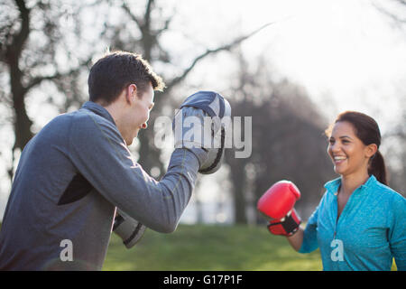 Young man and woman boxing training in park Stock Photo