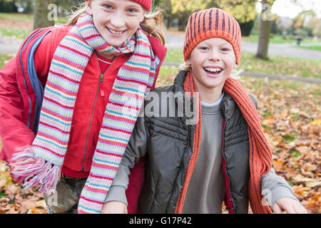 Brother and sister walking through park together, smiling Stock Photo