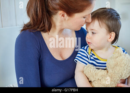 Mother and baby boy holding teddy bear Stock Photo