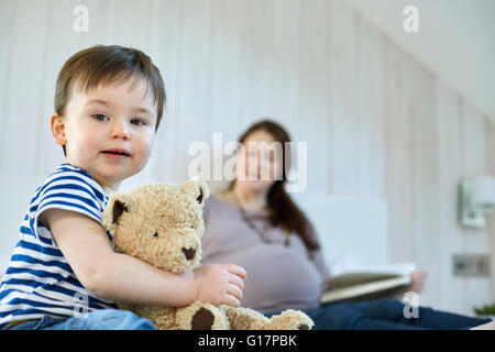 Baby boy holding teddy bear looking at camera Stock Photo