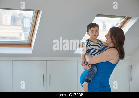 Side view of pregnant mother holding baby boy Stock Photo
