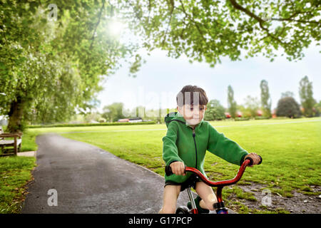 Boy cycling in park, Richmond, London Stock Photo