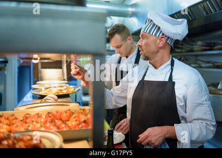 Chef checking order in traditional Italian restaurant kitchen
