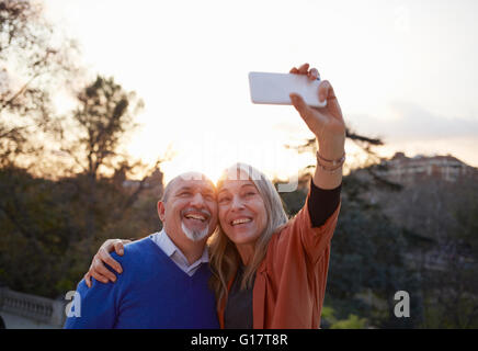 Couple using smartphone to take selfie smiling Stock Photo