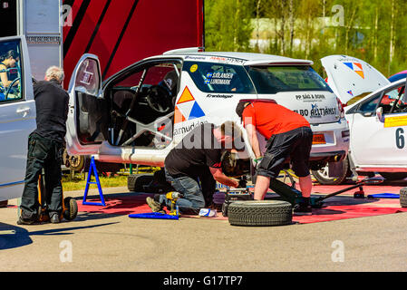 Emmaboda, Sweden - May 7, 2016: 41st South Swedish Rally in service depot. Crew working on rear brake disc on a white Citroen Ds Stock Photo