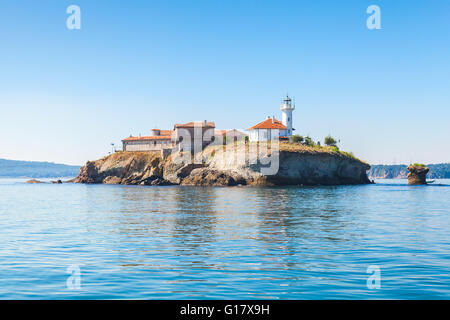 Saint Anastasia Island in Burgas bay, Black Sea, Bulgaria. Lighthouse tower and old wooden buildings on rocky coast Stock Photo
