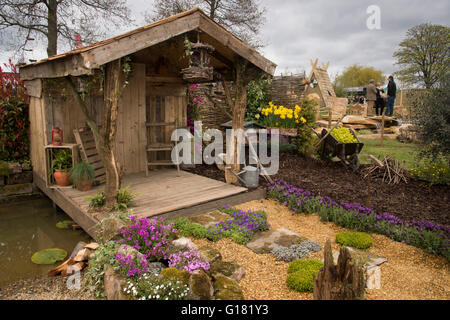 Harrogate Spring Flower Show 2016 (North Yorkshire, England) - rustic shelter, decking, pond and plants in the Wildlife Paradise' show garden. Stock Photo