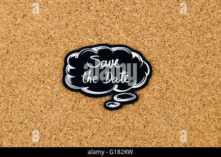 SAVE THE DATE written on black thinking bubble over cork board background, copy space available Stock Photo