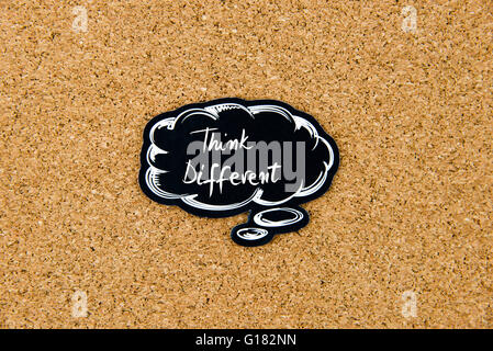 THINK DIFFERENT written on black thinking bubble over cork board background, copy space available Stock Photo