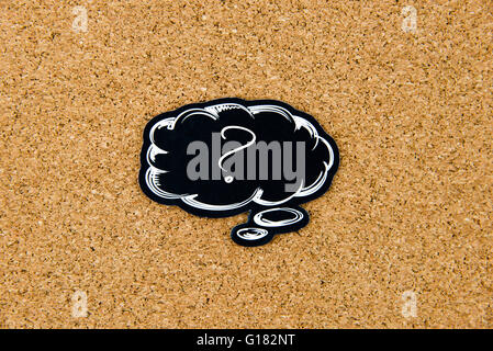 Question Mark written on black thinking bubble over cork board background, copy space available Stock Photo