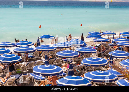 Baie Des Anges and blue sun umbrellas on beach, Nice, Cote D’Azur, France Stock Photo