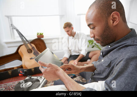 Side view of man at home using digital tablet Stock Photo