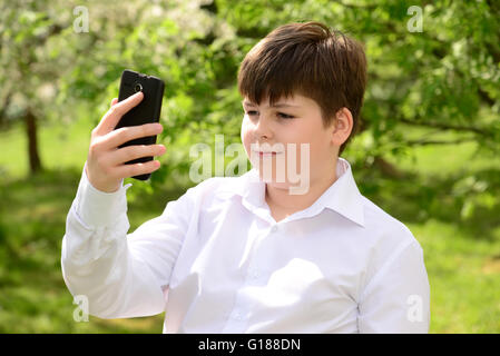 Teen boy talking on  phone outdoors Stock Photo