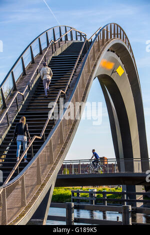 Cycle and pedestrian bridge, Melkwegbruk in Purmerend, North Holland, via a channel, arch bridge for pedestrians and cyclists Stock Photo