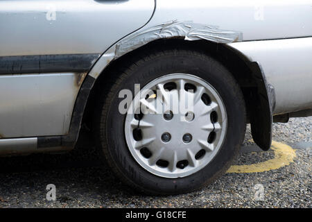 Rusted wheel arch on car held together by gaffer or elephant tape Stock Photo