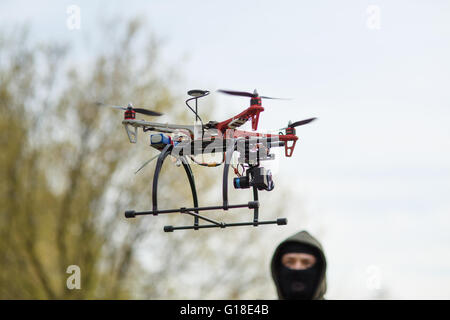 Man in mask operating a drone with remote control. Stock Photo