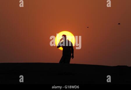 Allahabad, Uttar Pradesh, India. 11th May, 2016. Allahabad: An Indian youth talk on mobile during sunset in Allahabad on 11-05-2016. photo by prabhat kumar verma © Prabhat Kumar Verma/ZUMA Wire/Alamy Live News Stock Photo