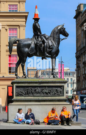 Glasgow, UK. 11th May, 2016. While many workers take a relaxing lunch break in the warm spring sunshine, the Duke of Wellington takes care by wearing an unusual sun hat. Credit:  Findlay/Alamy Live News Stock Photo