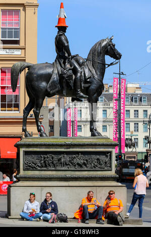 Glasgow, UK. 11th May, 2016. While many workers take a relaxing lunch break in the warm spring sunshine, the Duke of Wellington takes care by wearing an unusual sun hat. Credit:  Findlay/Alamy Live News Stock Photo