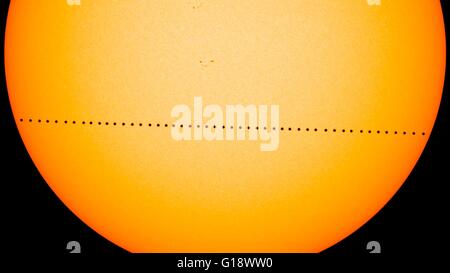 Composite image showing the planet Mercury in silhouette, lower third of image, as it transits across the face of the sun May 9, 2016 created with visible-light images from the Helioseismic and Magnetic Imager on SDO. Mercury passes between Earth and the sun only about 13 times a century, with the previous transit taking place in 2006. Stock Photo