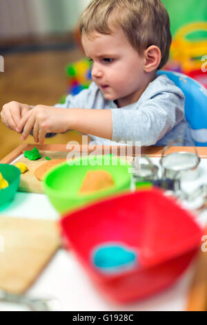 Little boy being creative with playdough Stock Photo