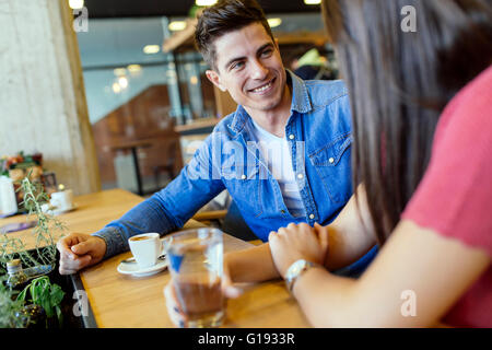 Happy young couple in restaurant waiting for food and talking Stock Photo